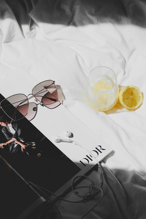 Free A magazine with sunglasses and a lemon on a bed Stock Photo