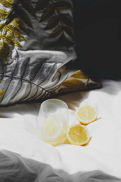 Lemon slices and a glass of water on a bed