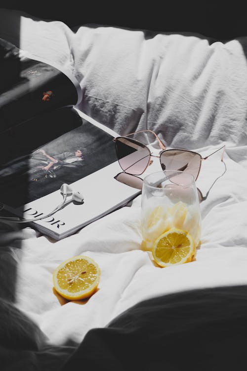 A book, a phone, and a lemon on a bed