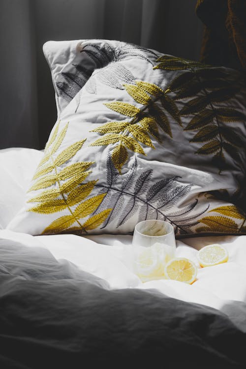A pillow with a yellow leaf and lemon on it
