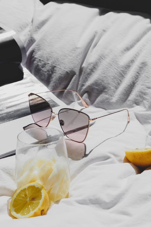Free A pair of sunglasses and lemon slices on a bed Stock Photo