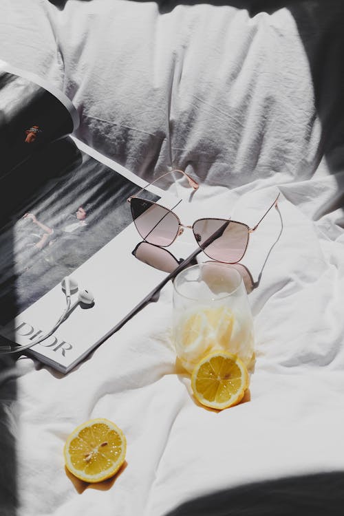 Free A magazine with sunglasses and lemon slices on a bed Stock Photo