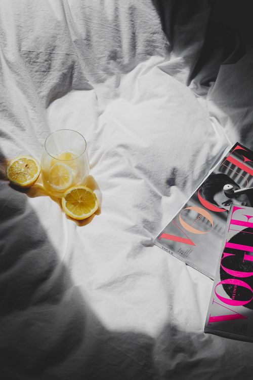Free An artistic still life with lemons, magazine, and subtle lighting on a white fabric. Stock Photo