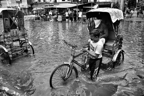 Free A rickshaw navigates through flooded Kolkata streets, reflecting urban resilience. Stock Photo