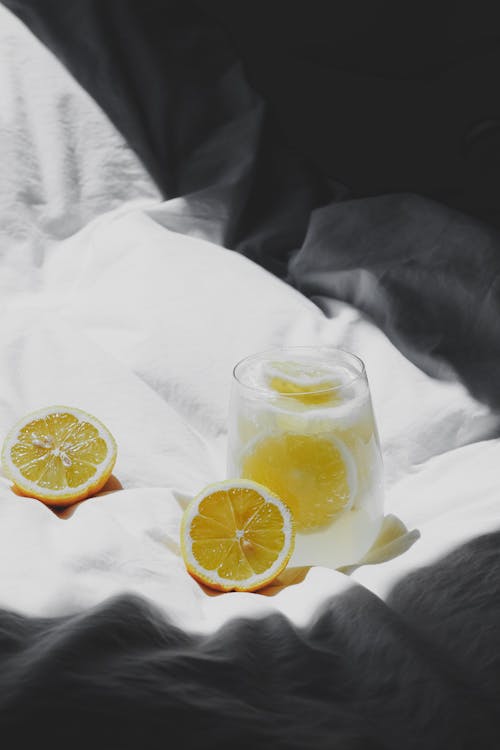 Free Lemonade and a glass of water on a bed Stock Photo