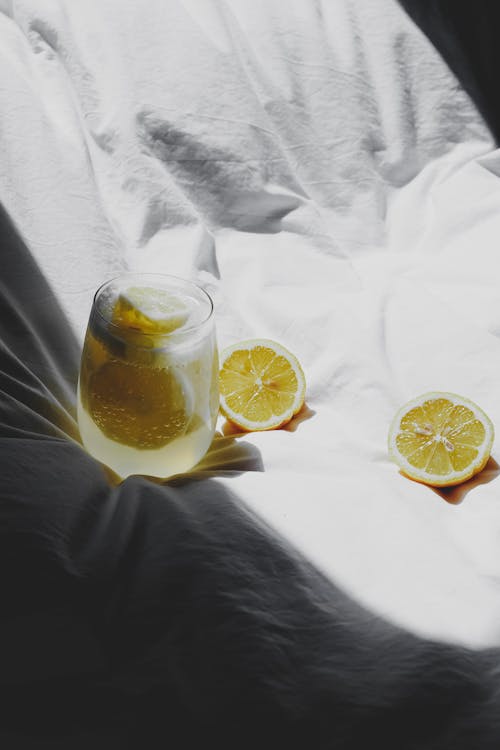 Free A glass of lemonade on a bed with two slices of lemon Stock Photo