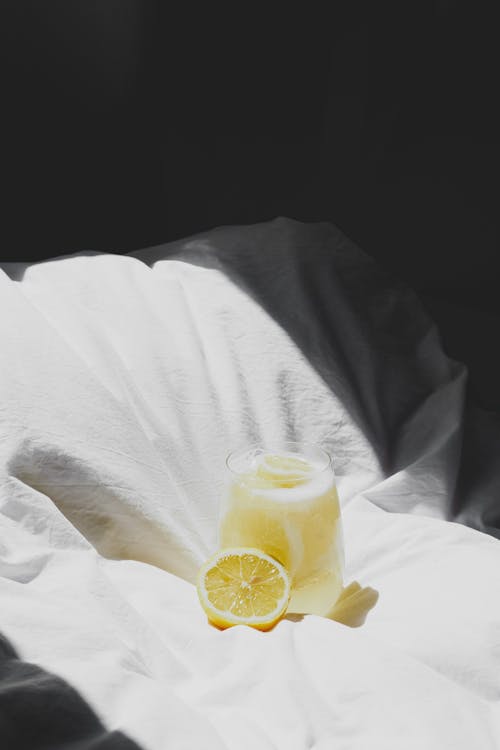 Free A lemonade glass on a bed with a lemon Stock Photo