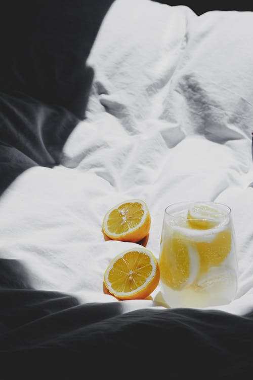 Free A glass of lemonade on a bed with a white sheet Stock Photo