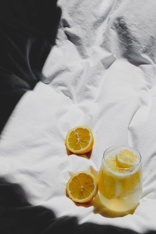 Free A glass of lemonade on a bed with two slices of lemon Stock Photo