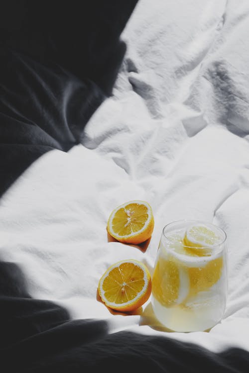 Free A glass of lemonade on a bed with a lemon slice Stock Photo