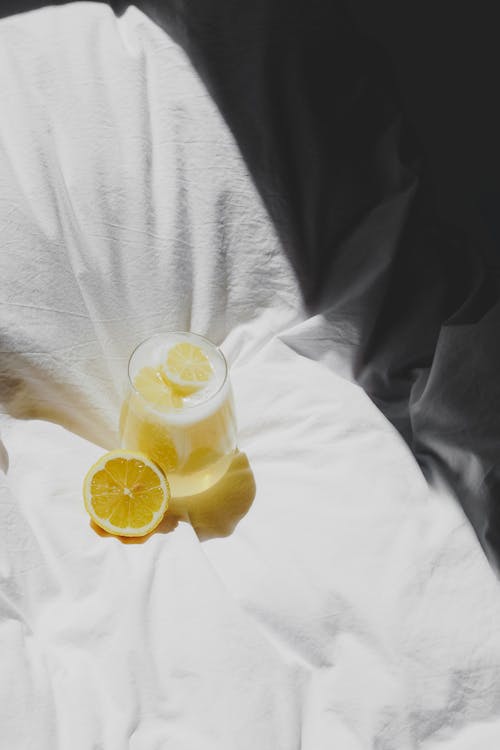 Free A lemon and a glass of water on a bed Stock Photo