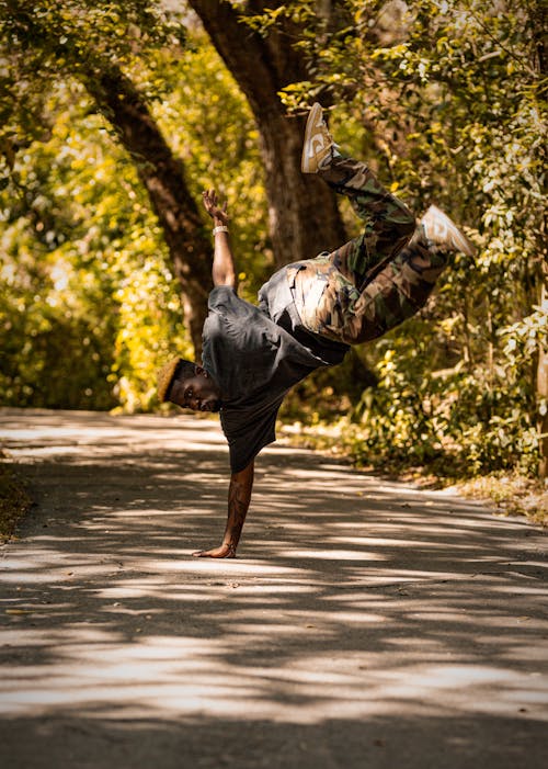 A Man Doing a Breakdance Pose in a Park 
