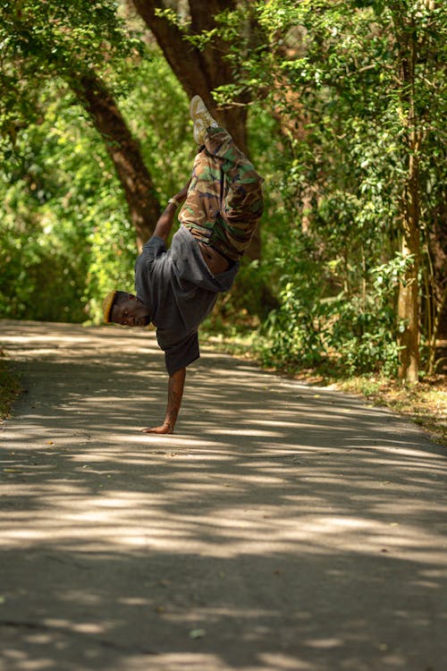 A Man Standing on One Hand in a Park 