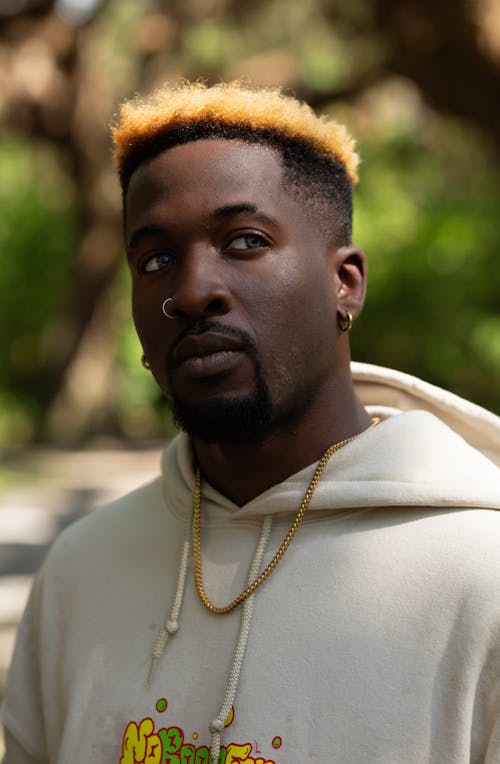 A Man in a Hoodie Standing in a Park