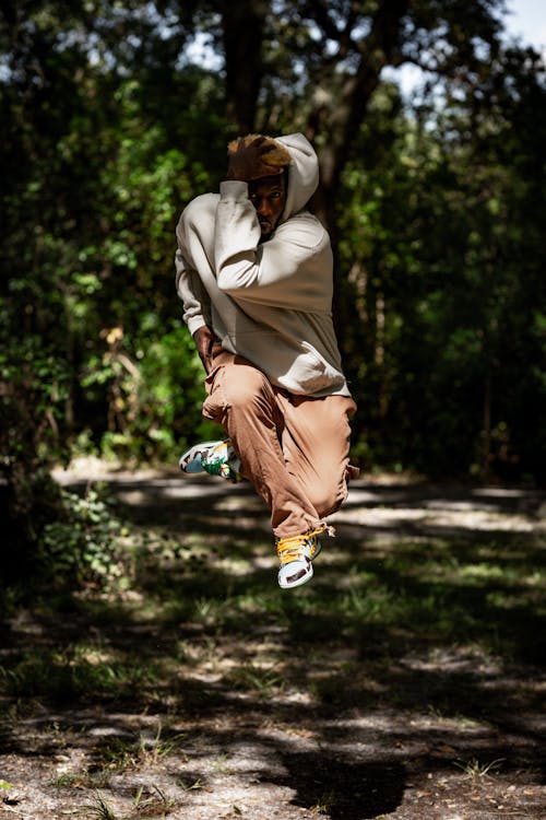 Photo of a Man in Casual Clothing Jumping in the Air