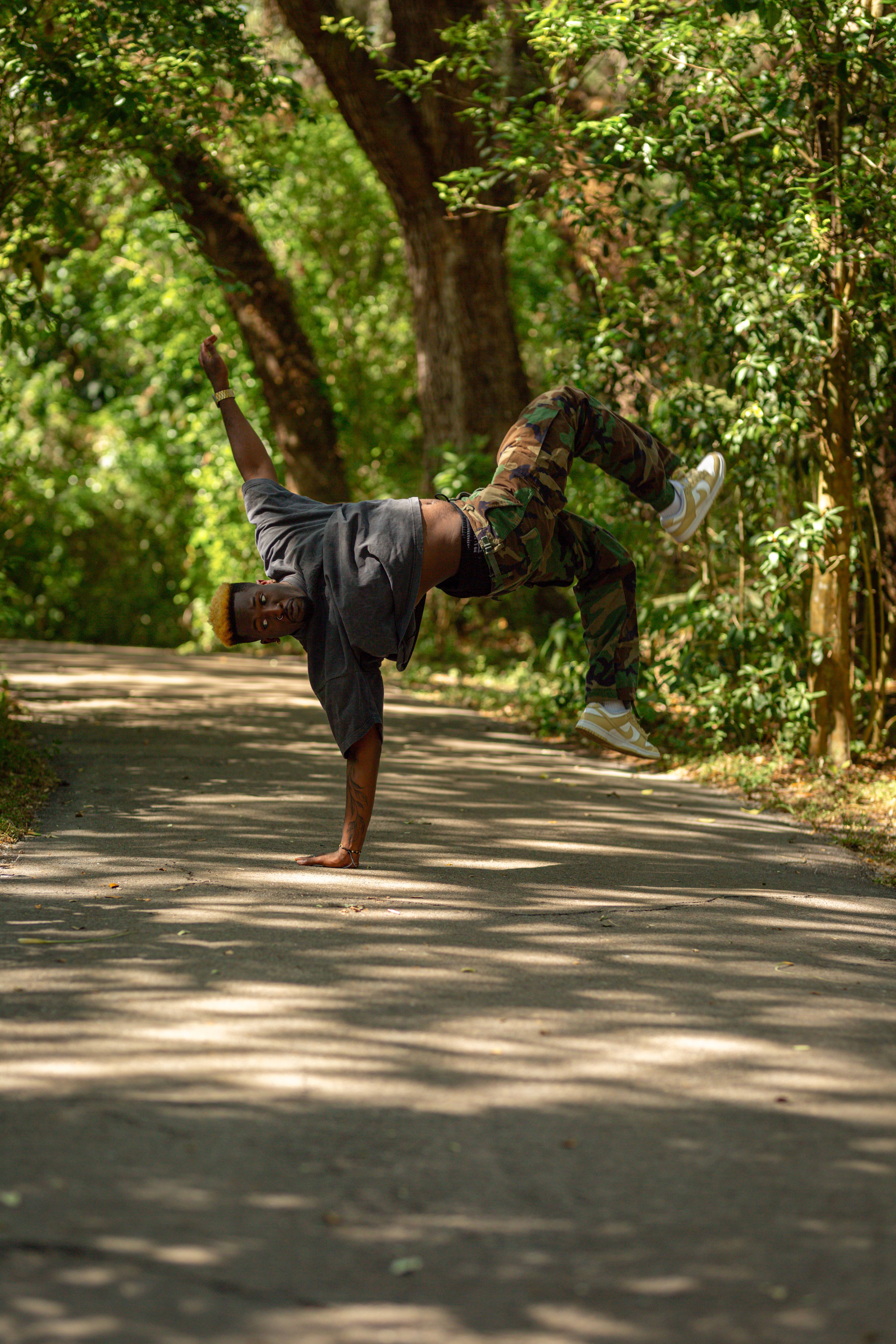 A dynamic acrobat showcasing athletic skills on a sunny forest path in Davie, FL.