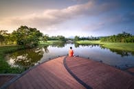 湖边独坐的宁静场景，映衬出日出时分大自然的美丽