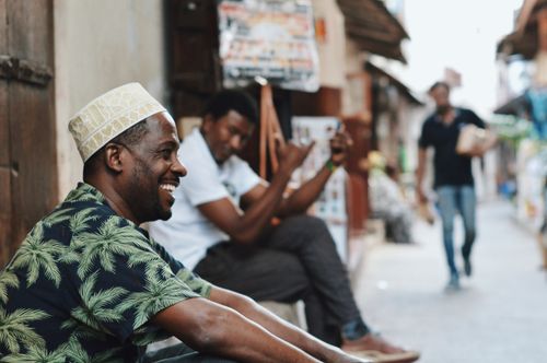 Free Casual street scene in Zanzibar City with men enjoying the day. Capturing vibrant street life and culture. Stock Photo