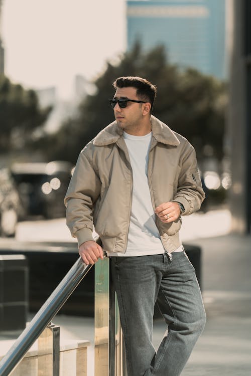 Man in Sunglasses and Outerwear Posing near Handrails on Street