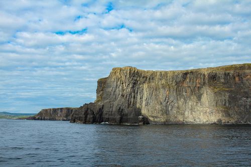 Free Explore majestic sea cliffs with rugged beauty under a dramatic cloudscape. Stock Photo