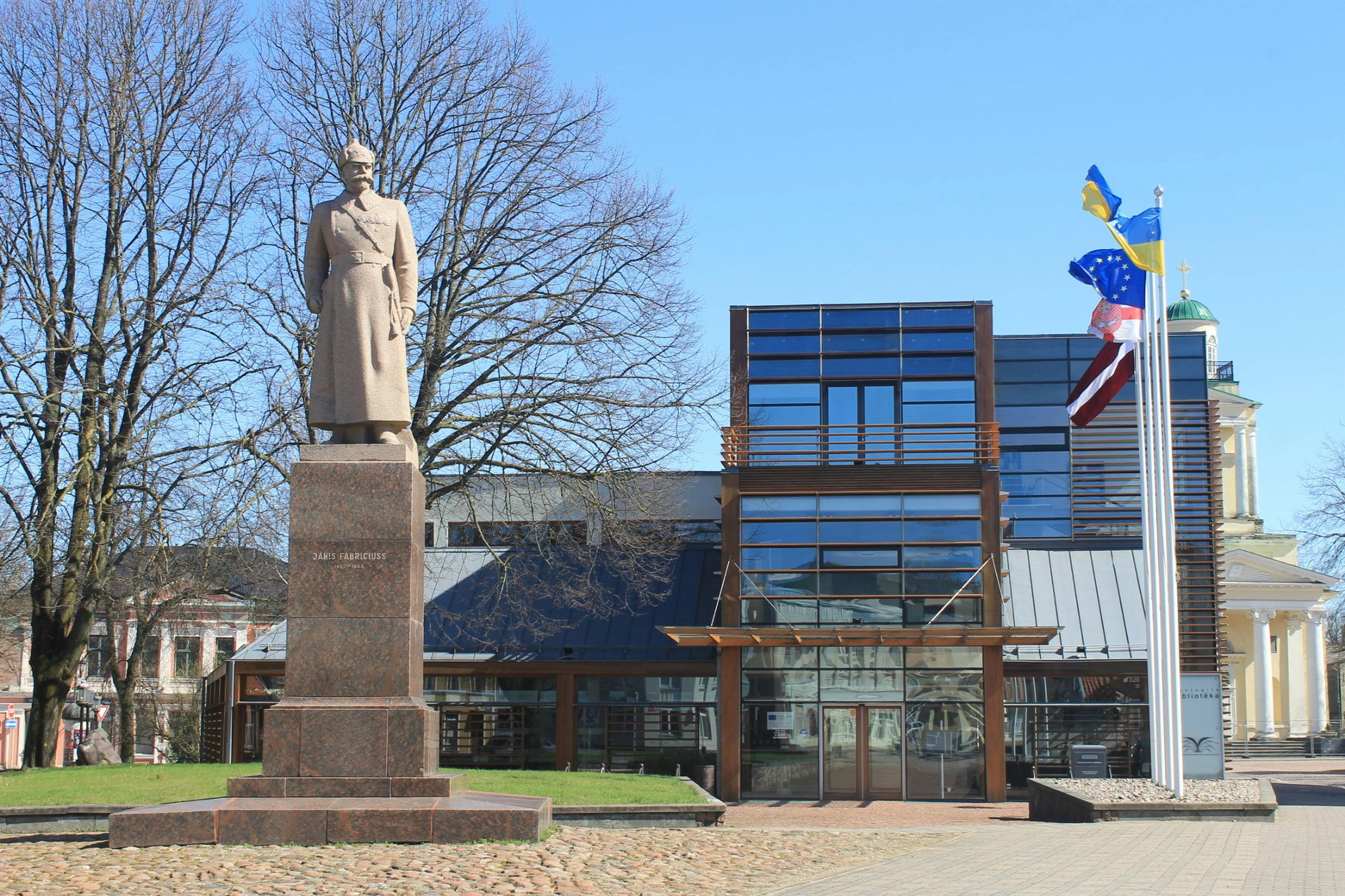 Explore the iconic statue of Rifleman Janis Fabriciuss outside the modern library in Ventspils, Latvia.