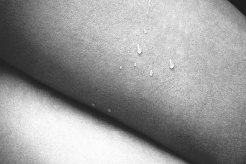 A black and white photo of a woman's legs with water drops