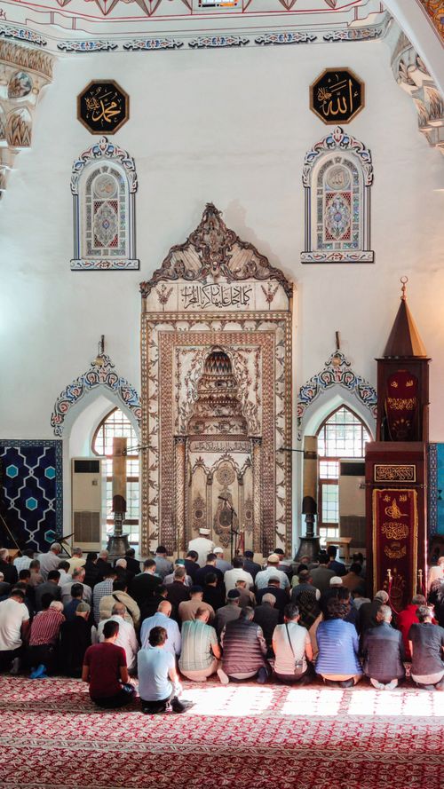 Free Men gathered in prayer at the Muradiye Mosque in Bursa, Turkey, highlighting 15th-century Islamic architecture. Stock Photo