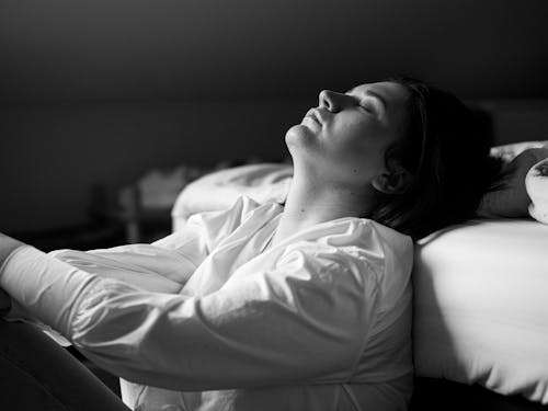 Free A woman laying on a bed with her eyes closed Stock Photo