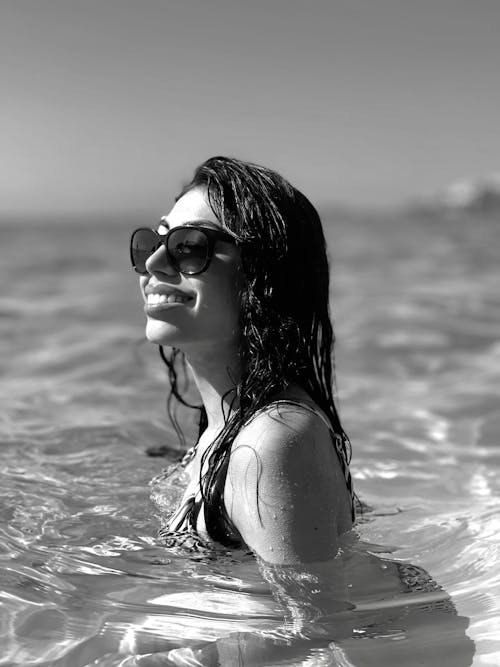 A woman in sunglasses is in the water