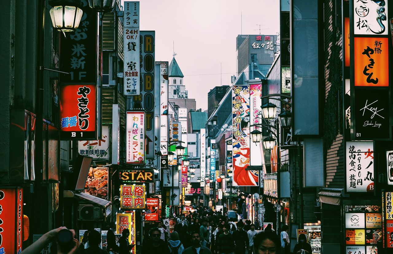bustling tokyo shopping street filled with signs and pedestrians in th