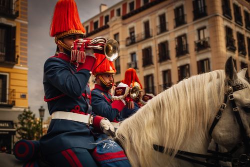 Free Spanish Royal Guard in uniform playing trumpets during a parade. Urban setting. Stock Photo