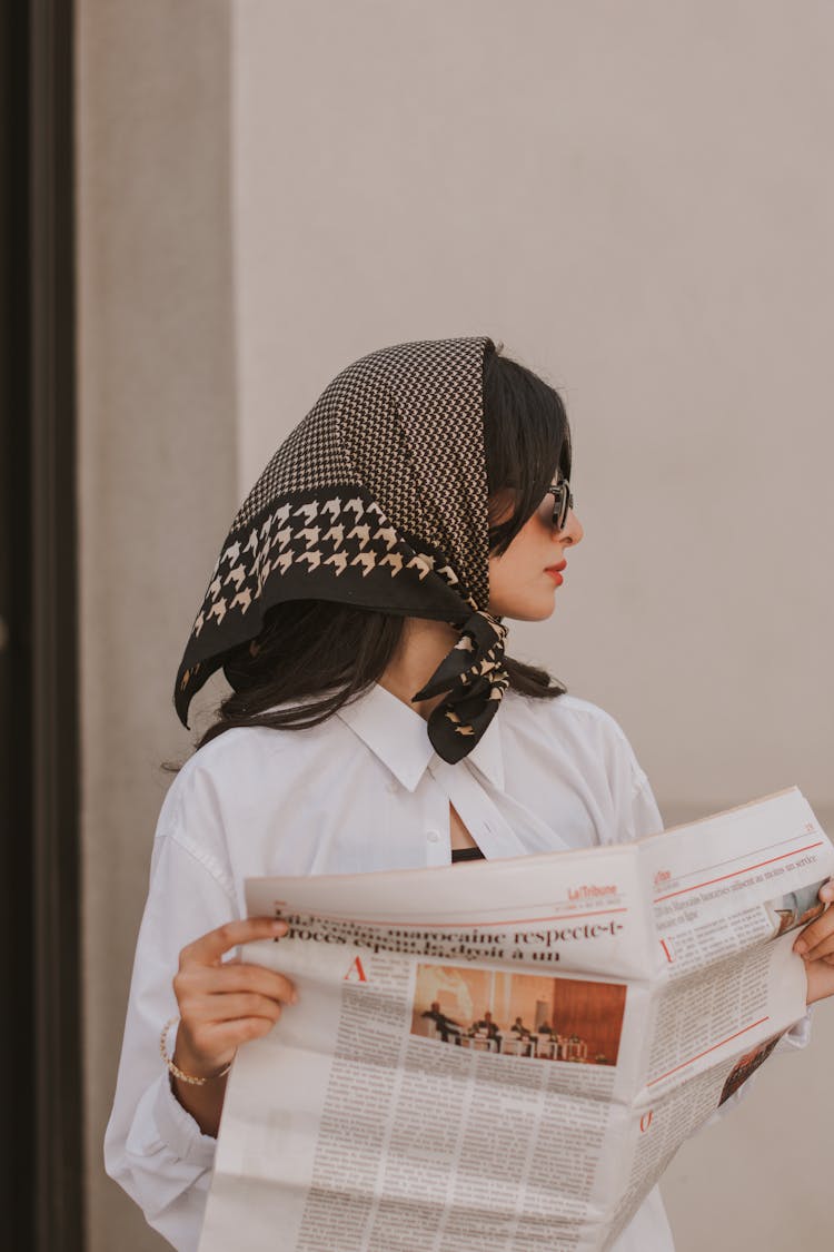 Woman With Headscarf Reading A Newspaper 