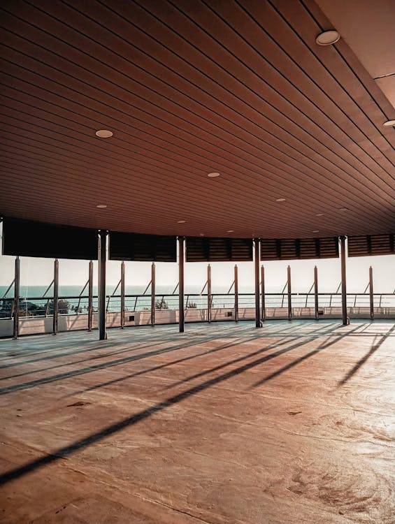 A large empty room with wooden floors and a large window