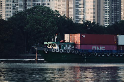 A large green boat with a large container on it