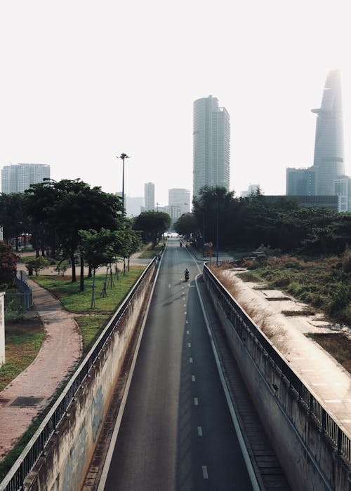 A city street with a long empty road and tall buildings