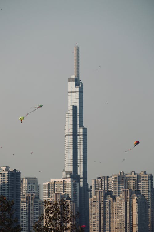 A kite flies in the sky above a city skyline