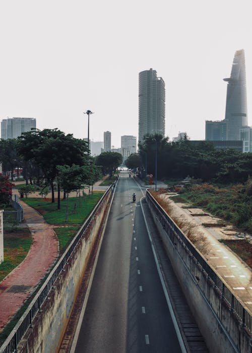 A city street with a long empty road and tall buildings