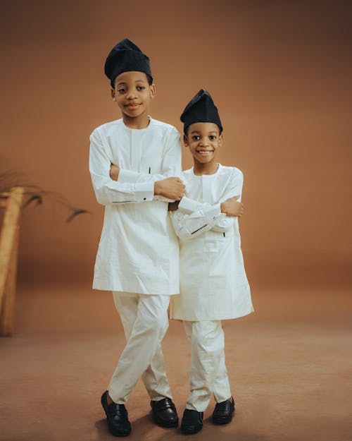 Two young boys in traditional clothing pose for a photo