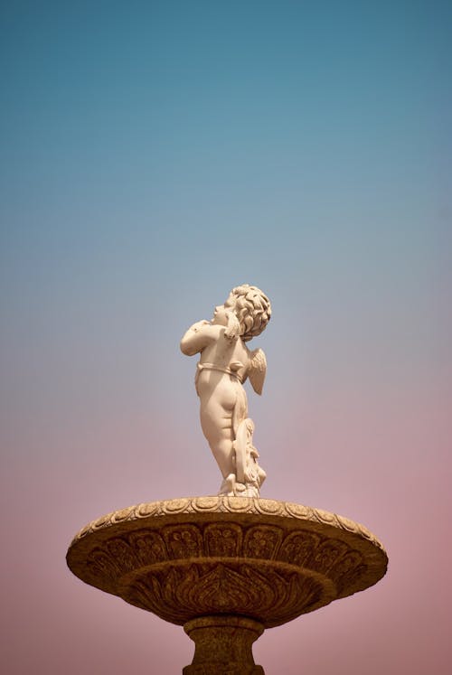 A statue of a little boy on top of a fountain