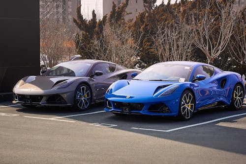 Two blue sports cars parked in a parking lot