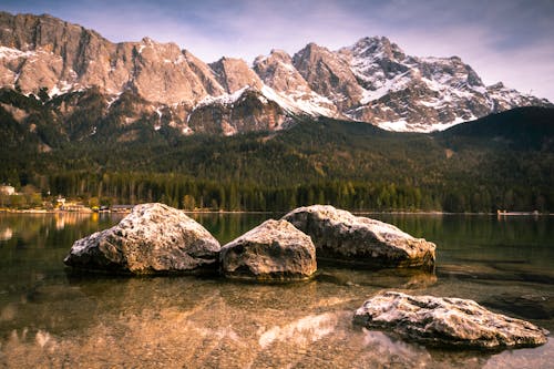A lake with rocks and mountains in the background