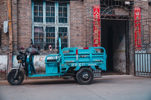 Gratis stockfoto met bakstenen gebouw, blauwe scooter, gemodificeerde