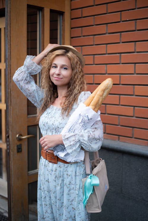 Free A woman holding a baguette and a bag Stock Photo