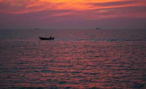 A boat is out on the water at sunset