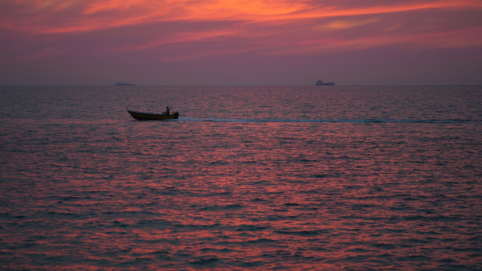 Silhouette of motorboat on sea at dusk, Eritrea