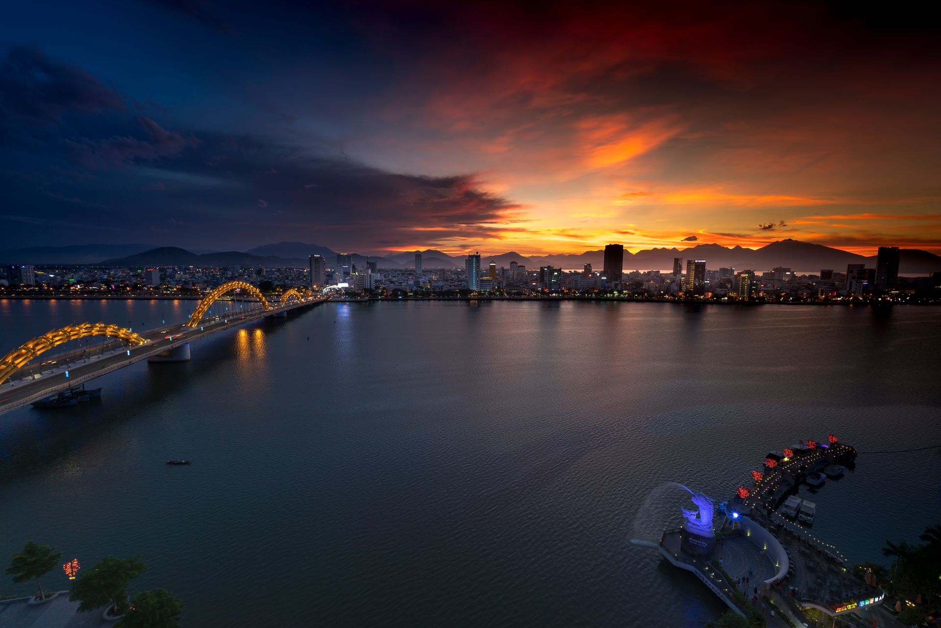 Captivating sunset view of a city skyline across a bridge and river, offering urban tranquility.