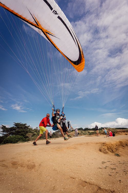 Free Tandem paragliding takeoff on a sandy beach in Pénestin, France. Perfect vacation adventure! Stock Photo