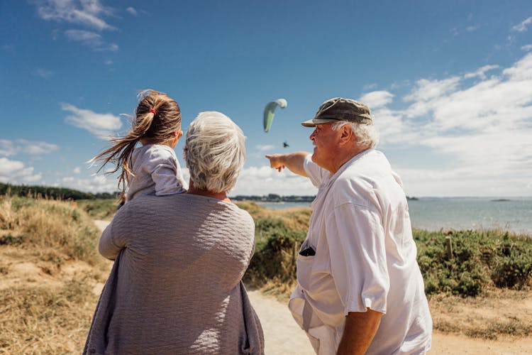 Elderly Couple With Granddaughter By The Sea 