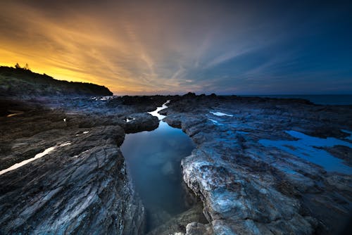 免費 黎明時岩石海岸的照片 圖庫相片