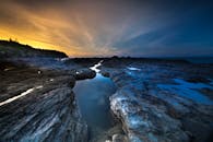 岩石海岸线上的戏剧性日落，捕捉到宁静的海洋风景